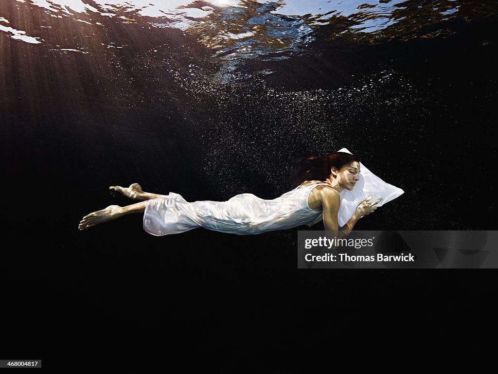 Woman with head on pillow sleeping underwater