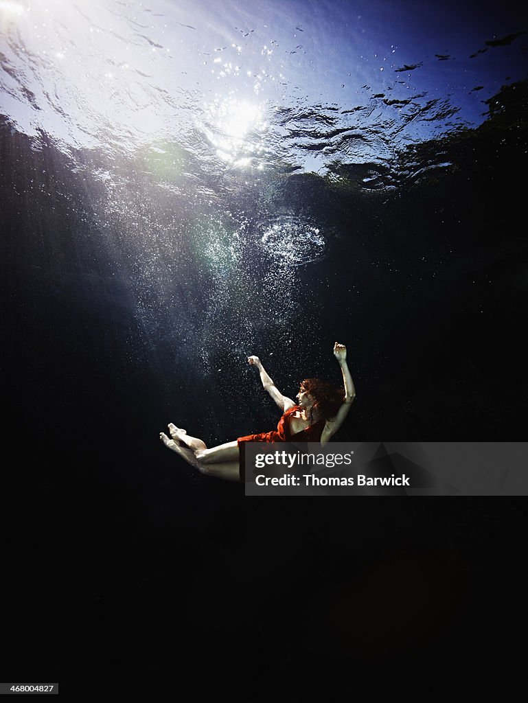 Underwater view of woman falling through water