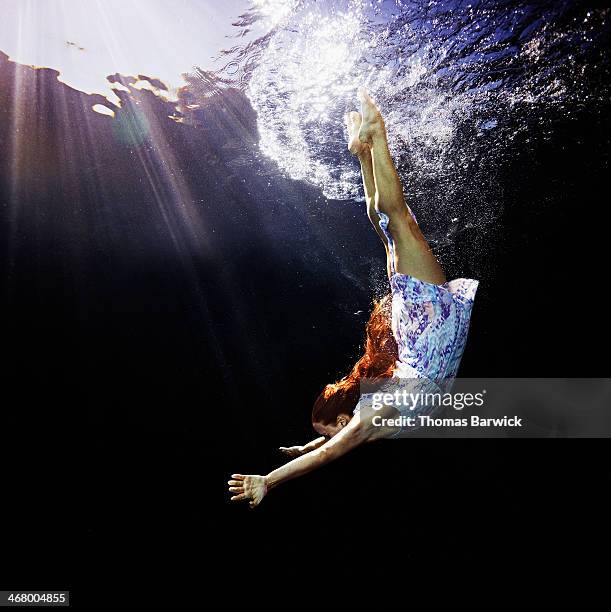 woman in blue dress diving underwater - den sprung wagen stock-fotos und bilder