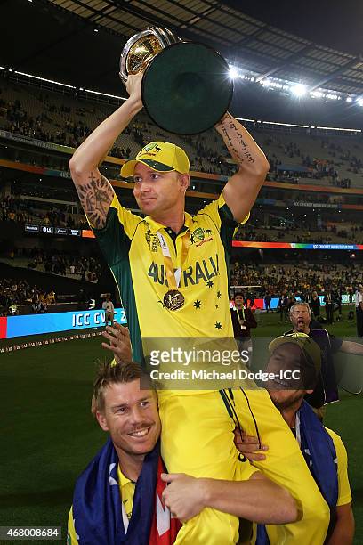 Australian captain Michael Clarke is lifted up by teamates David Warner and Aaron Finch winning during the 2015 ICC Cricket World Cup final match...