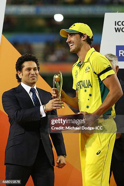 Mitchell Starc of Australia receives a trophy from Indian legend Sachin Tendulkar for being the best player of the tournament during the 2015 ICC...