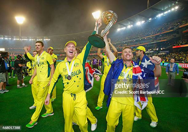 Brad Haddin and David Warner of Australia hold the World Cup trophy aloft as they celebrate winning the 2015 ICC Cricket World Cup final match...