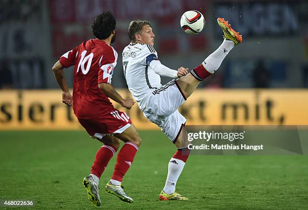 Bastian Schweinsteiger of Germany controls the ball against Tornike Okriashvili of Georgia during the EURO 2016 Group D Qualifier match between...