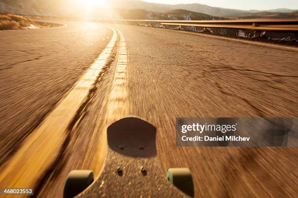 pov of a longboard skateboard going down the road. - extreme sports point of view stock pictures, royalty-free photos & images