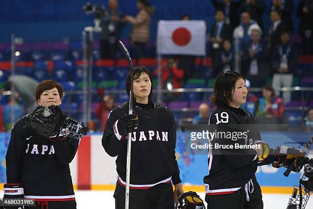 Shiori Koike, Sena Suzuki and Miho Shishiuchi of Japan react after the Women's Ice Hockey Preliminary Round Group B Game on day two of the Sochi 2014...