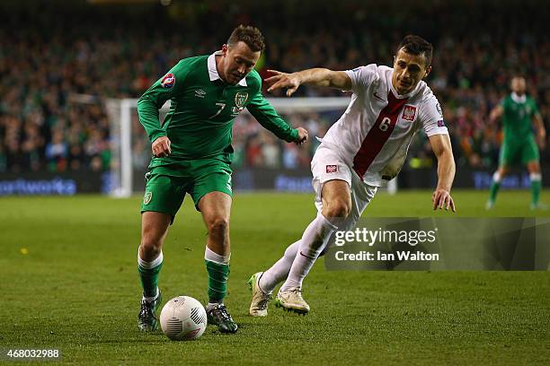 Aiden McGeady of Republic of Ireland and Tomasz Jodlowiec of Poland compete for the ball during the EURO 2016 Qualifier match between Republic of...