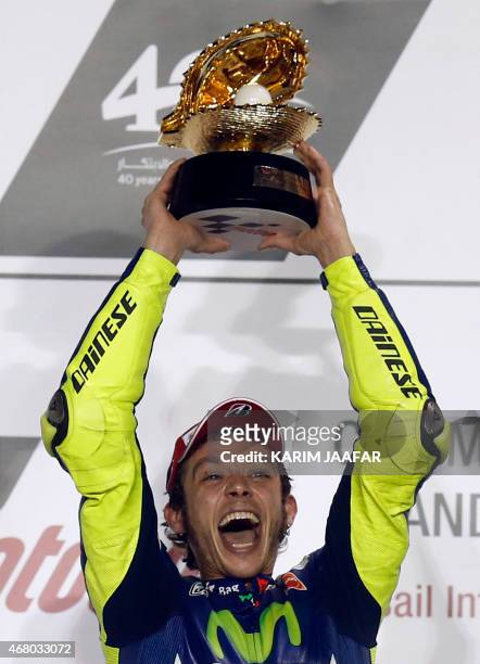 Movistar Yamaha MotoGP rider Valentino Rossi of Italy celebrates with his trophy on the podium after winning the MotoGP race of the Qatar Grand Prix...