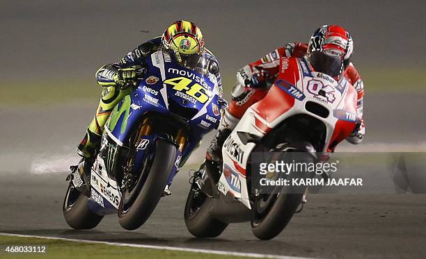 Italian MotoGP rider Valentino Rossi of the Movistar Yamaha team races with Andrea Dovizioso of Italy during the MotoGP race of the Qatar Grand Prix...