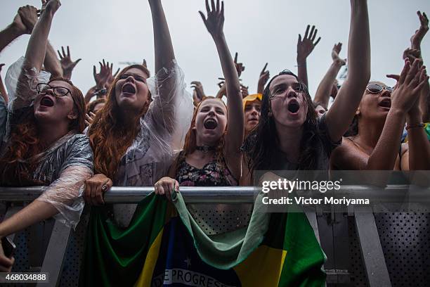 The crowd watch Interpol perform in the rain during 2015 Lollapalooza Brazil at Autodromo de Interlagos on March 29, 2015 in Sao Paulo, Brazil.