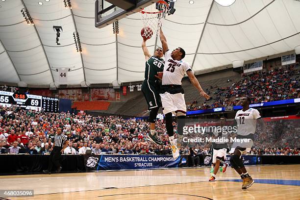 Travis Trice of the Michigan State Spartans shoots the ball against Wayne Blackshear of the Louisville Cardinals in the second half of the game...