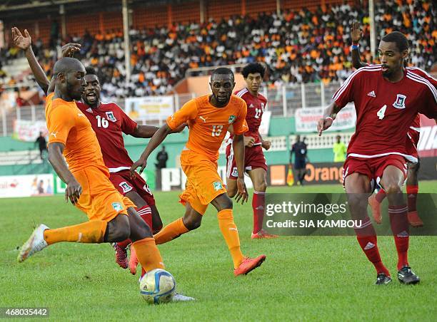 Equatorial Guinea's Armando Sipoto vies with Ivory Coast's Jean-Daniel Akpa Akpro and Sio Giovani during the friendly football match Ivory Coast...