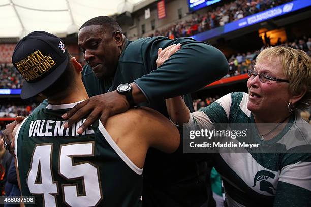 Denzel Valentine of the Michigan State Spartans celebrates with his parents Carlton and Kathy after defeating the Louisville Cardinals 76 to 70 in...