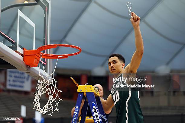 Travis Trice of the Michigan State Spartans celebrates by cutting down the net after defeating the Louisville Cardinals 76 to 70 in overtime of the...