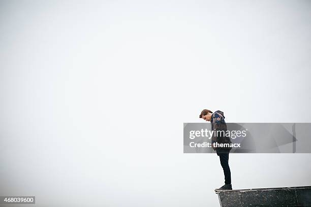 young man standing on stone block - suicide stock pictures, royalty-free photos & images