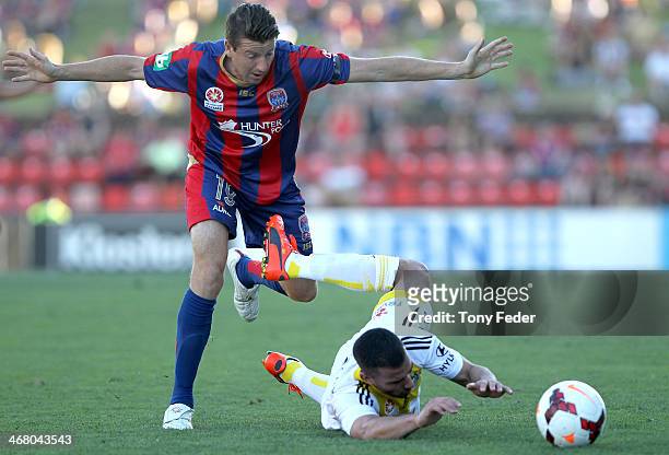 Emmanuel Muscat of the Phoenix is tackled by Michael Bridges of the Jets during the round 18 A-League match between the Newcastle Jets and Wellington...