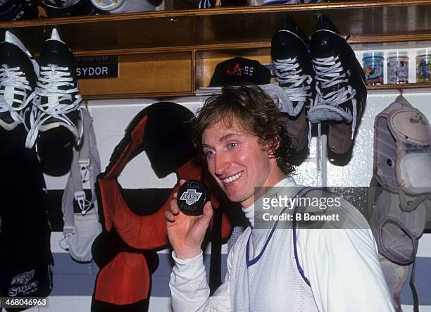 Wayne Gretzky of the Los Angeles Kings poses with the puck he scored his 802nd career goal with after the game against the Vancouver Canucks on March...