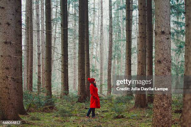 woman walking along wooded road - red hat white people stock pictures, royalty-free photos & images