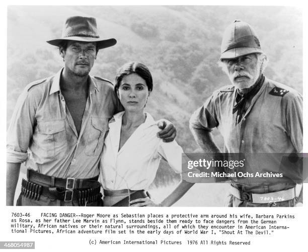 Actor Roger Moore, Barbara Parkins and actor Lee Marvin pose on set of the movie "Shout at the Devil " , circa 1976.