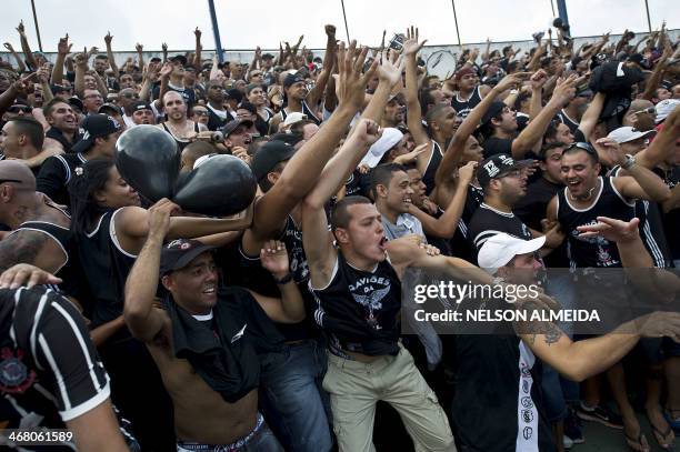 Members of Brazilian Corinthians' torcida , Gavioes da Fiel, cheer for their team during the 2014 Paulista championship football match against...