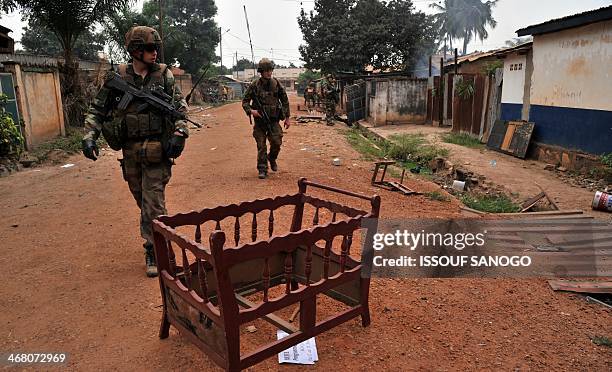 French soldiers of the Sangaris military operation walk past a just abandoned looted cradle as they patrol in the 5th district of Bangui on February...