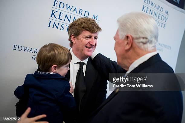 Former Rep. Patrick Kennedy, D-R.I., holds his son Owen as he talks with former Rep. Jim Moran, D-Va. During a gala that was part of the dedication...
