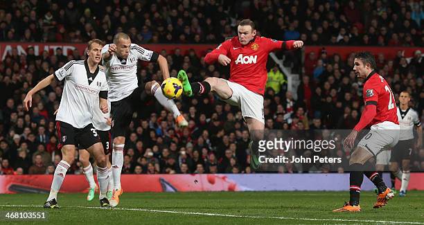 Wayne Rooney of Manchester United in action with John Heitinga of Fulham during the Barclays Premier League match between Manchester United and...