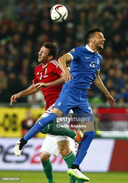Daniel Tozser of Hungary and Andreas Samaris of Greece vie for the ball during their Euro 2016 qualification soccer match at Grupama Arena in...
