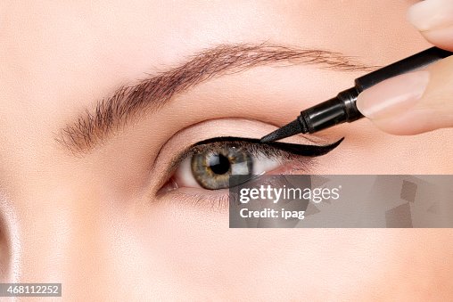 Green eyed beautiful model applying foundation with a brush Green eyed beautiful model applying foundation with a brush