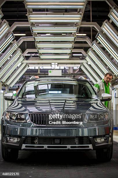 Worker completes a quality control inspection on a finished Skoda Octavia automobile on the production line at Volkswagen AG's Skoda Auto AS...