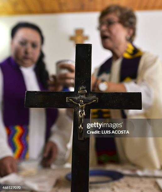 Colombian priest Olga Lucia Alvarez , assisted by Aida Soto officiates a mass in Bogota on March 23, 2015. Alvarez is one of the four Latin American...