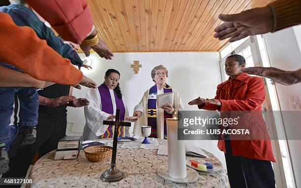 Colombian priest Olga Lucia Alvarez , assisted by Aida Soto , officiates a mass in Bogota on March 22, 2015. Alvarez is one of the four Latin...