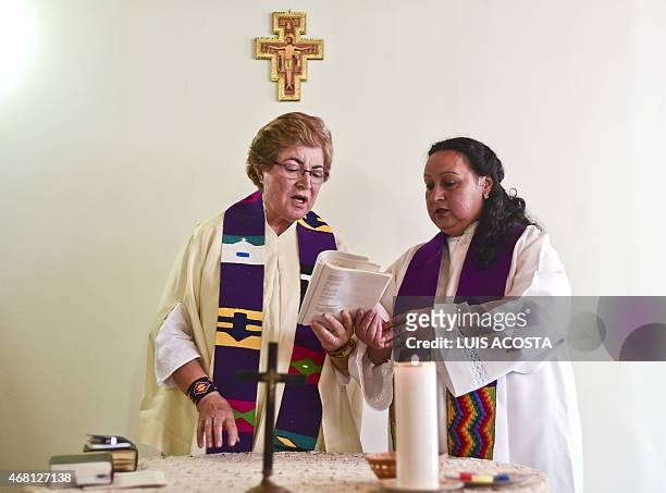 Colombian priest Olga Lucia Alvarez , assisted by Aida Soto, officiates a mass in Bogota on March 22, 2015. Alvarez is one of the four Latin American...