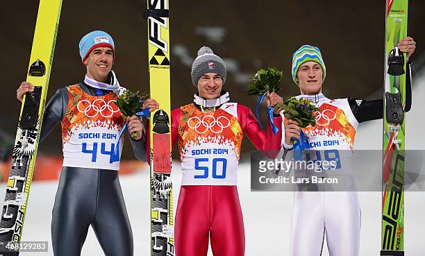 Bronze medalist Anders Bardal of Norway, gold medalist Kamil Stoch of Poland and silver medalist Peter Prevc of Slovenia pose after the flower...