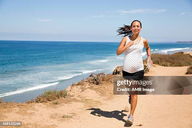 linda mulher grávida jogging ao longo da costa para manter caber - short track imagens e fotografias de stock