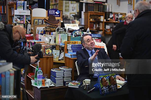 Candidate for the Gordon constituency Alex Salmond signs books during the first day of the British General Election campaign on March 30, 2015 in...