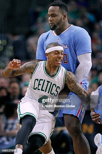 Celtics guard Isaiah Thomas reacts as he runs into a considerably larger player, former Celtics forward Glen "Big Baby" Davis, as he tries to work...