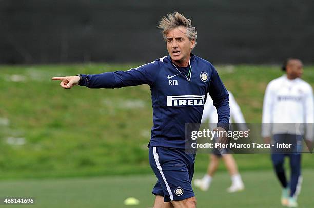 Head Coach of FC Internazionale Roberto Mancini speaks with his team player during the FC Internazionale training session at Appiano Gentile on March...