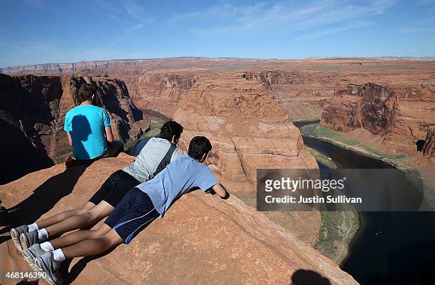 People lie on the edge of a cliff to view the Colorado River at Horseshoe Bend on March 30, 2015 in Page, Arizona. As severe drought grips parts of...