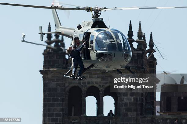 Stuntmen perform a battle hanging from a helicopter during the filming of the latest James Bond movie 'Spectre' at Zocalo Main Dquare on March 28,...