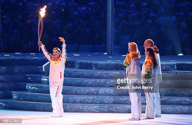 Alina Kabaeva of Russia carries the Olympic Torch during the Opening Ceremony of the 2014 Winter Olympic Games at the Fisht Olympic Stadium on...