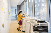 Full length of businesswoman using photocopier