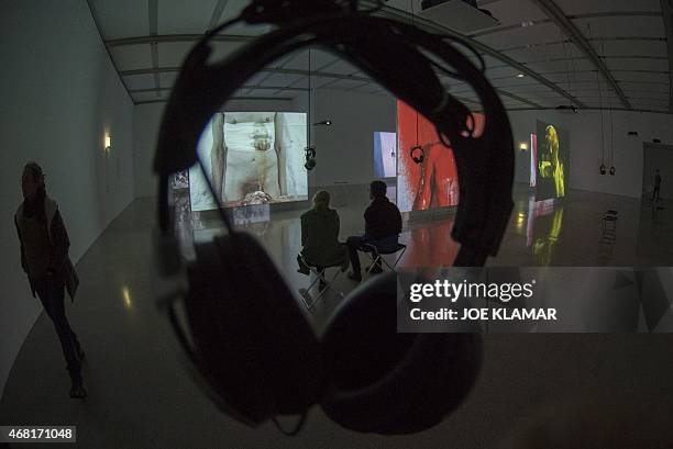 Lifestyle-Austria-art-exhibition,FEATURE Visitors watch large screens projecting art performances of Otto Muehl and other famous artists known as...