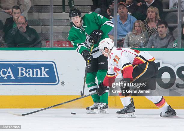 John Klingberg of the Dallas Stars makes a pass to a teammate against Mikael Backlund of the Calgary Flames at the American Airlines Center on March...