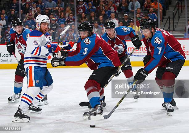 John Mitchell of the Colorado Avalanche controls the puck as Nate Guenin of the Colorado Avalanche defends against Matt Fraser of the Edmonton Oilers...