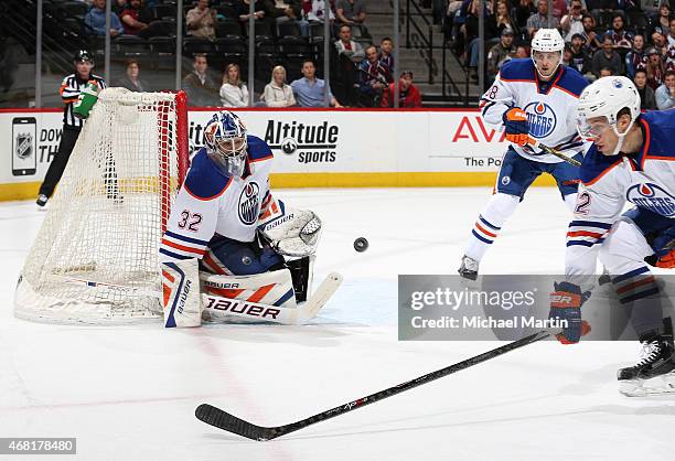 Goaltender Richard Bachman of the Edmonton Oilers keeps his eye on the puck as teammates Keith Aulie and Brandon Davidson defend against the Colorado...