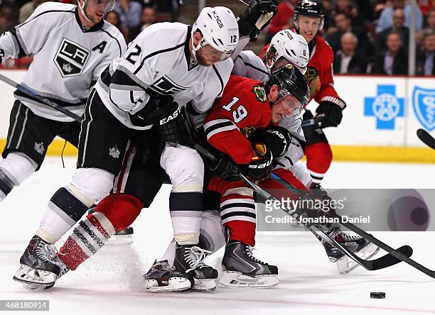 Jonathan Toews of the Chicago Blackhawks tries to get off a shot as he's squeezed by Marian Gaborik and Jake Muzzin of the Los Angeles Kings at the...