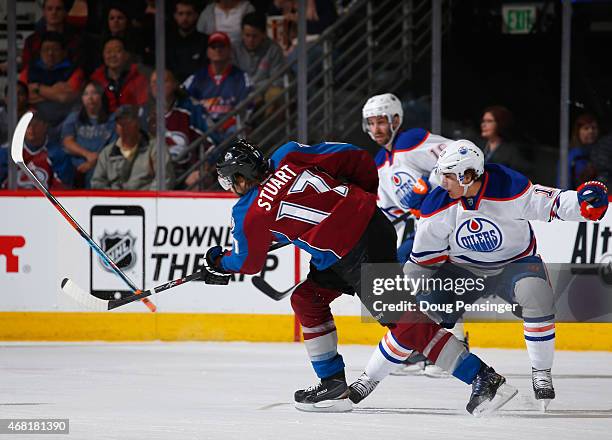 Brad Stuart of the Colorado Avalanche takes a slapshot and knocks the stick out of the hand of Nail Yakupov of the Edmonton Oilers at Pepsi Center on...