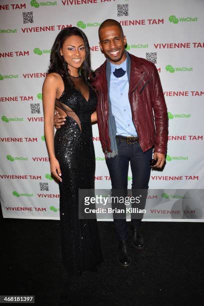 Actors Tashiana Washington and Eric West pose backstage before the start of the Vivienne Tam show during Mercedes-Benz Fashion Week Fall 2014 at The...