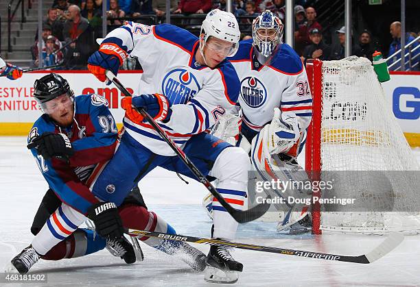 Gabriel Landeskog of the Colorado Avalanche and Keith Aulie of the Edmonton Oilers battle for control of the puck as goalie Richard Bachman of the...