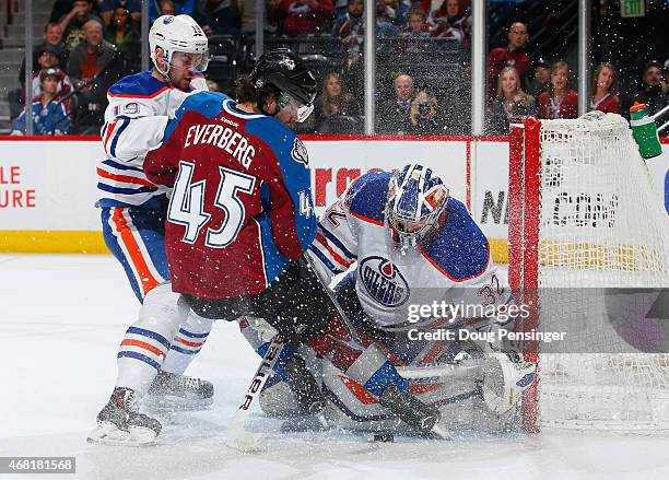 Goalie Richard Bachman of the Edmonton Oilers looks to control the puck as Dennis Everberg of the Colorado Avalanche and Justin Schultz of the...